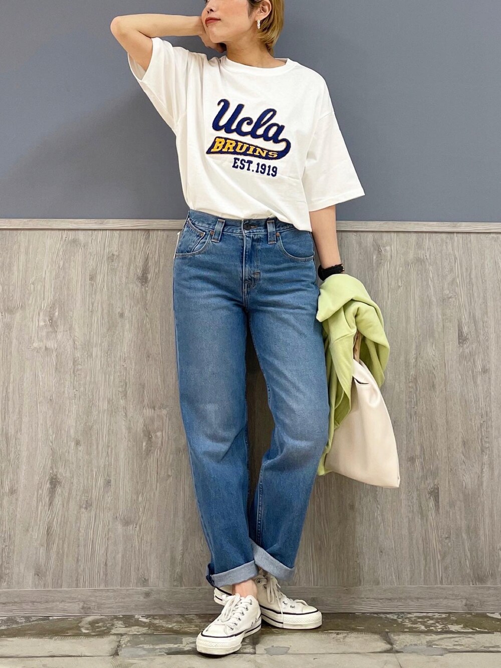 ホワイト系のTシャツ/カットソー、グリーン系のカーディガン/ボレロ、ブルー系のデニムパンツを着用したレディースの春コーディネートの4枚目の写真