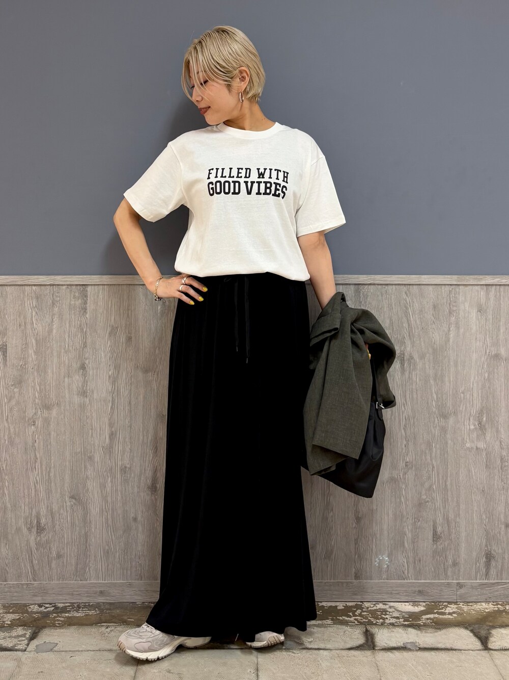 グレー系のテーラードジャケット、ホワイト系のTシャツ/カットソー、ブラック系のスカートを着用したレディースの夏コーディネートの3枚目の写真