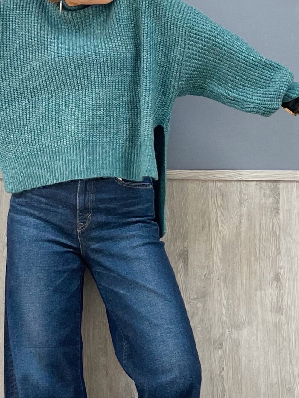 ブルー系のデニムパンツ、グリーン系のニット/セーターを着用したレディースの冬コーディネートの2枚目の写真