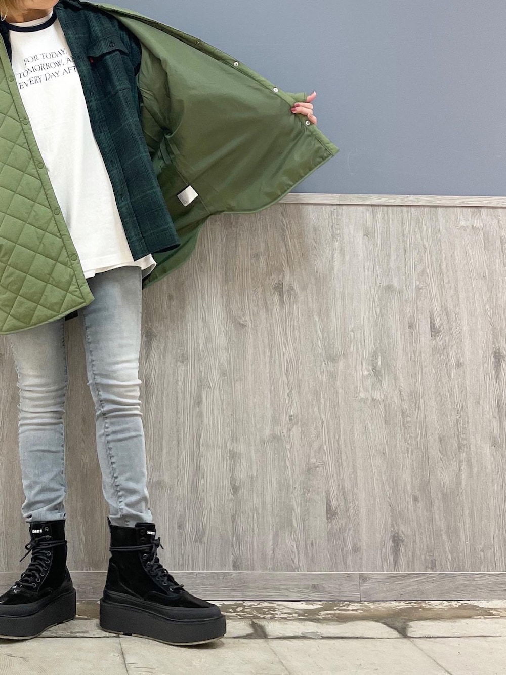 グレー系のショルダーバッグ、グレー系のデニムパンツ、ブルー系のTシャツ/カットソーを着用したレディースの冬コーディネートの2枚目の写真