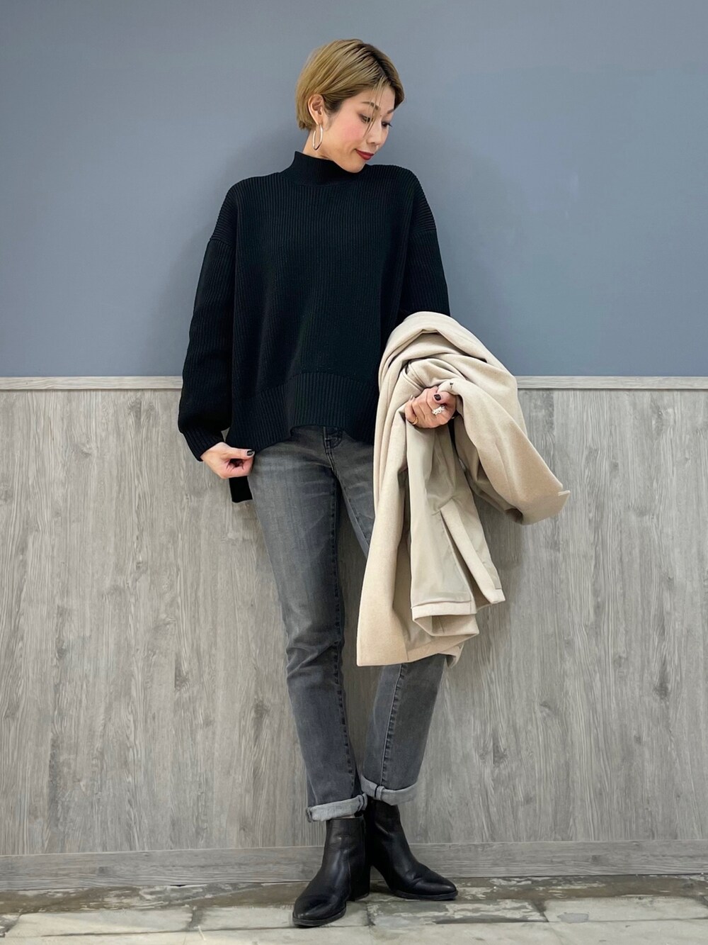 ブラック系のニット/セーター、グレー系のデニムパンツ、ブラック系のブーツを着用したレディースの冬コーディネートの4枚目の写真