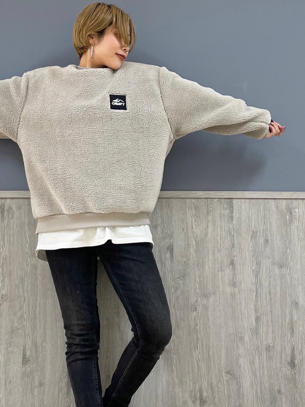 ブラック系のデニムパンツ、ホワイト系のTシャツ/カットソー、グレー系のスウェットを着用したレディースの冬コーディネートの2枚目の写真