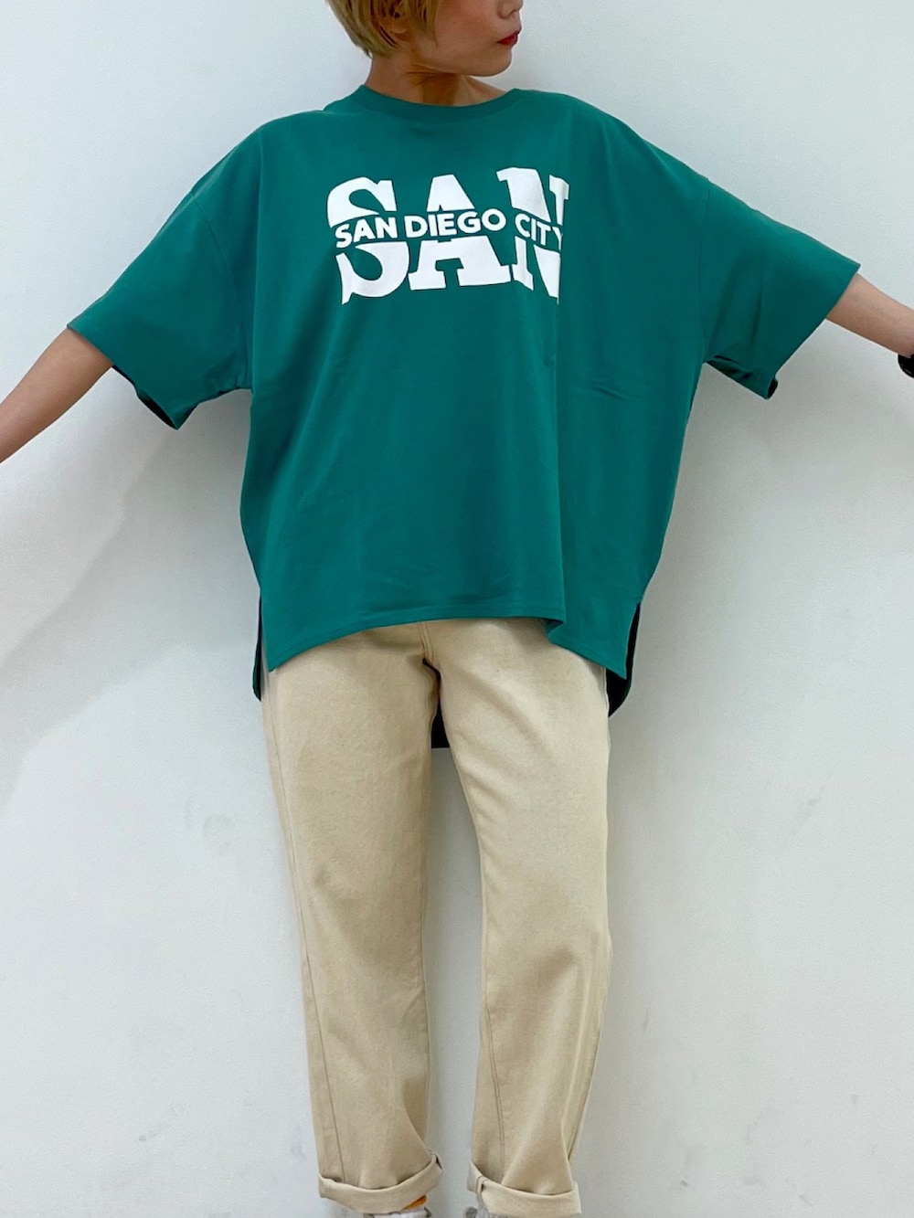 ホワイト系のデニムパンツ、グリーン系のTシャツ/カットソー、ベージュ系のトートバッグを着用したレディースの夏コーディネートの3枚目の写真