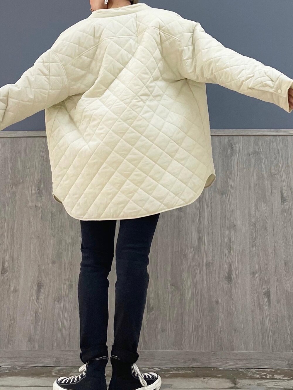 ブラック系のショルダーバッグ、ホワイト系のニット/セーター、ホワイト系のTシャツ/カットソーを着用したレディースの冬コーディネートの5枚目の写真