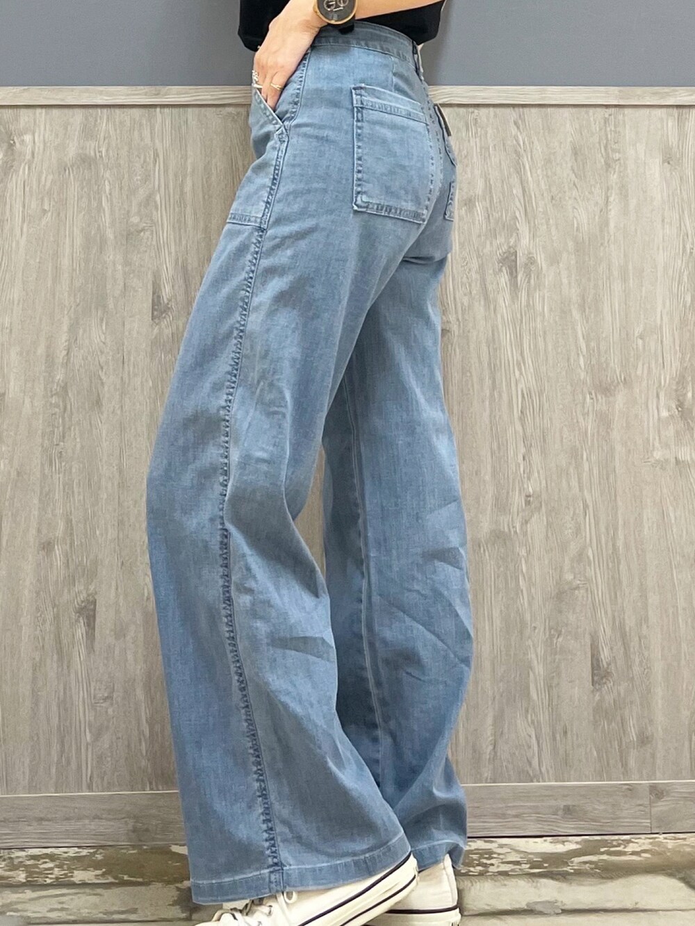 ブラック系のTシャツ/カットソー、ホワイト系のショルダーバッグ、ブルー系のデニムパンツを着用したレディースの春コーディネートの4枚目の写真