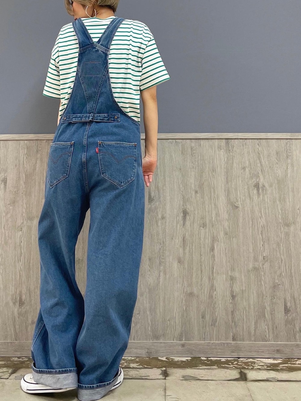 ブルー系のサロペット/オーバーオール、ベージュ系のトートバッグ、グリーン系のTシャツ/カットソーを着用したレディースの夏コーディネートの4枚目の写真