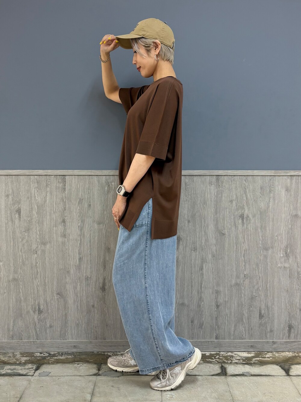 ブラウン系のニット/セーター、ブルー系のデニムパンツ、ベージュ系のキャップを着用したレディースの夏コーディネートの2枚目の写真