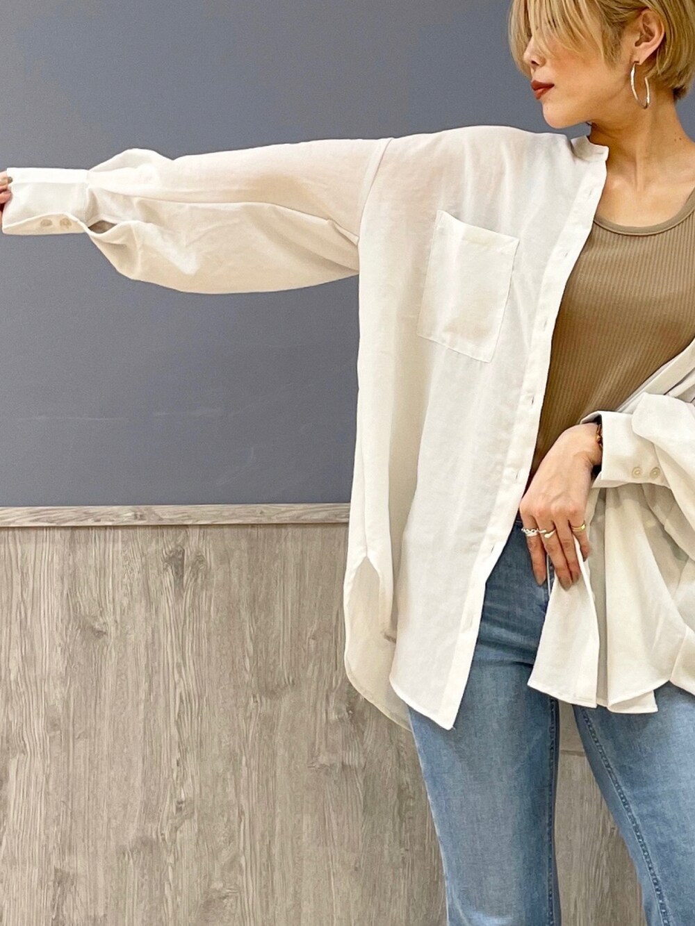 ブルー系のデニムパンツ、ベージュ系のショルダーバッグ、ベージュ系のタンクトップを着用したレディースの春コーディネートの2枚目の写真