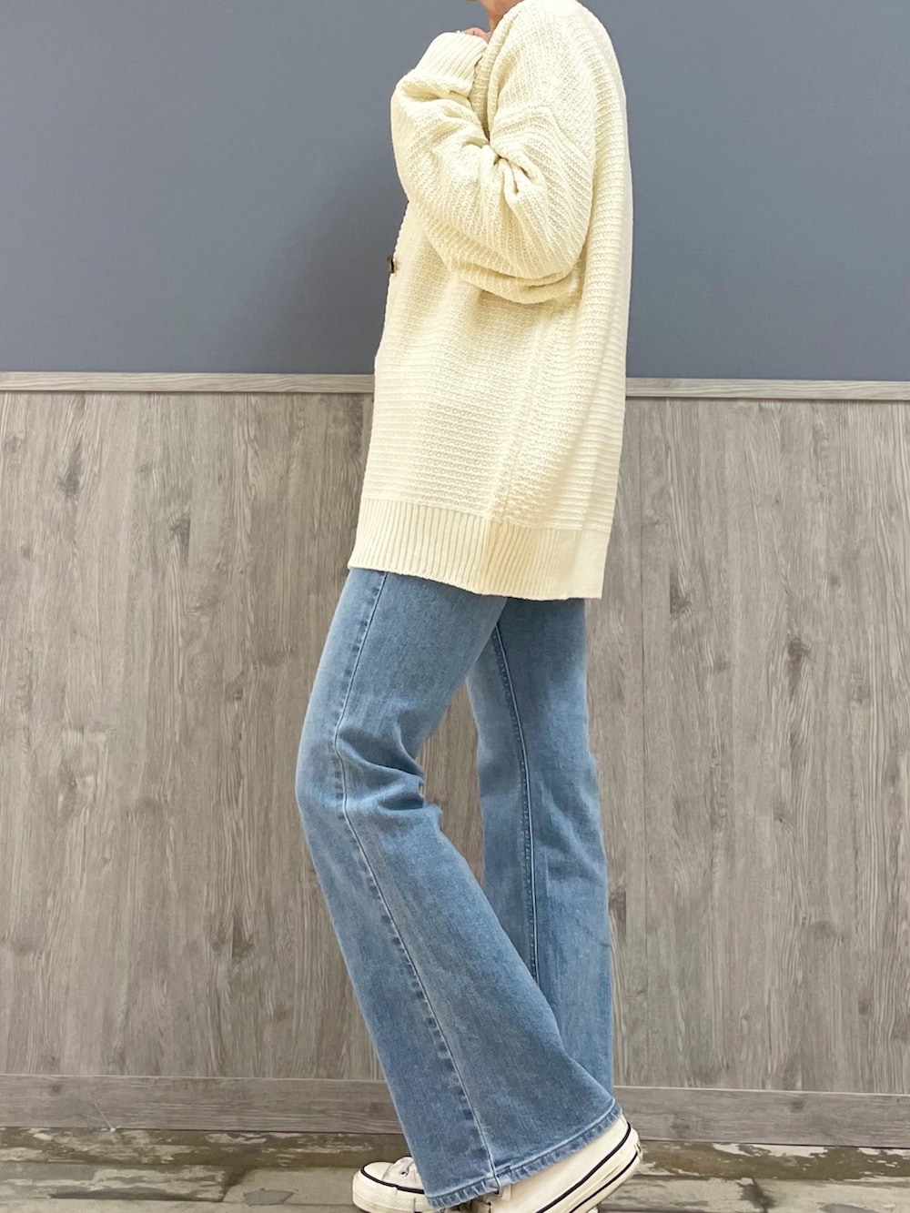 ホワイト系のショルダーバッグ、ホワイト系のカーディガン/ボレロ、ブルー系のデニムパンツを着用したレディースの冬コーディネートの2枚目の写真