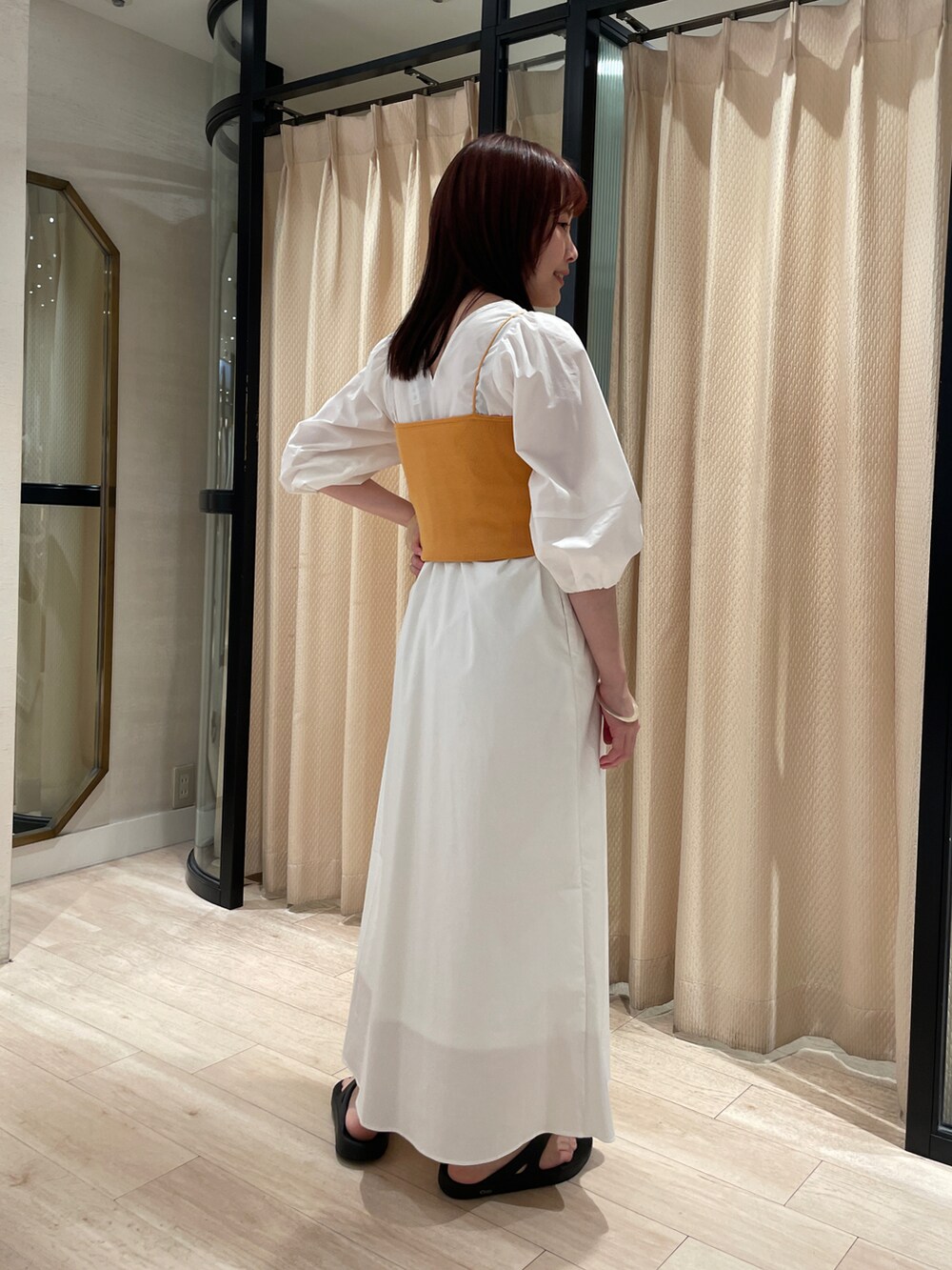 ホワイト系のワンピース、イエロー系のキャミソールを着用したレディースの夏コーディネートの2枚目の写真