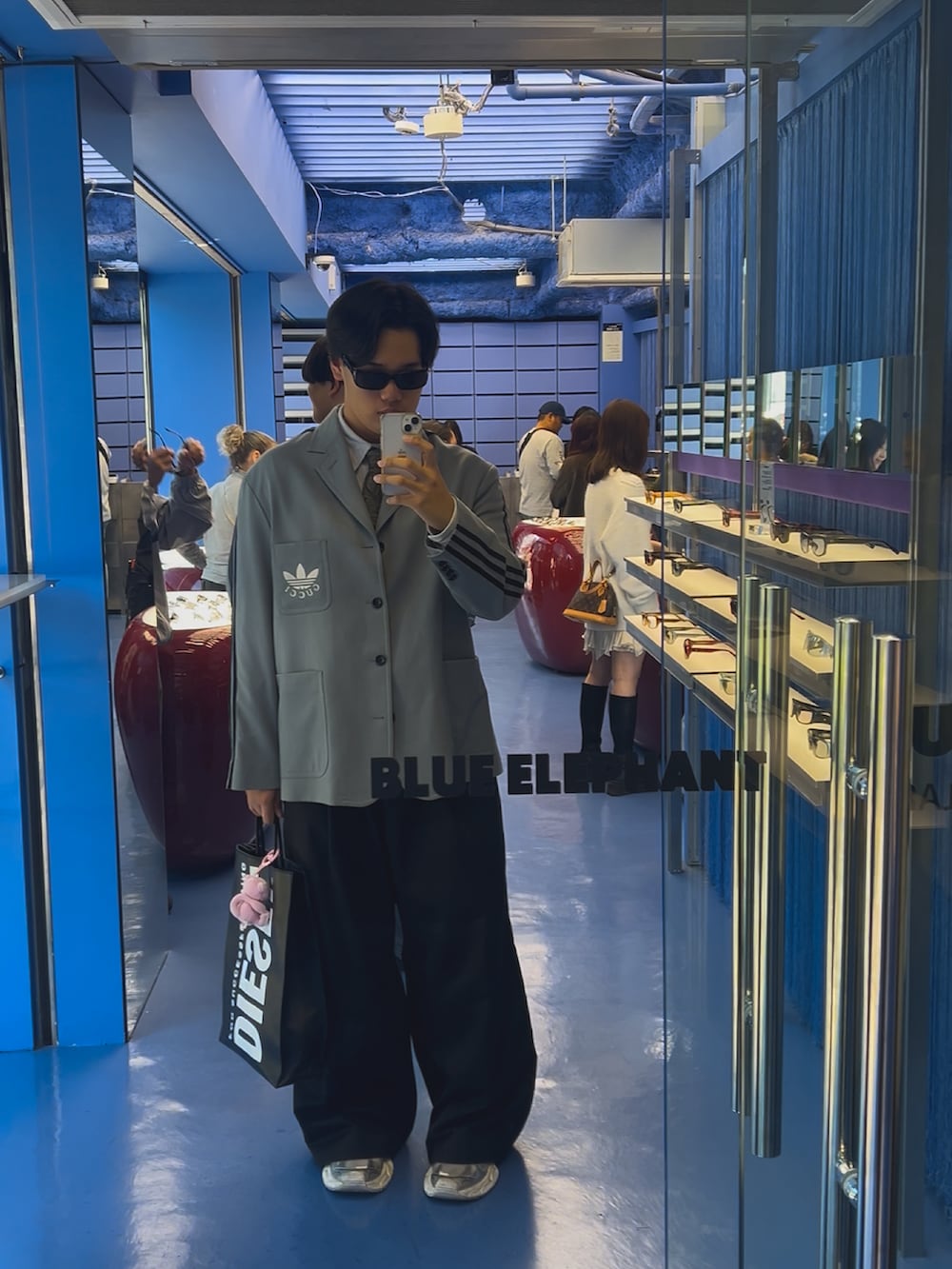 グレー系のテーラードジャケット、ブラック系のその他パンツ、ホワイト系のスニーカーを着用したメンズの秋コーディネートの2枚目の写真