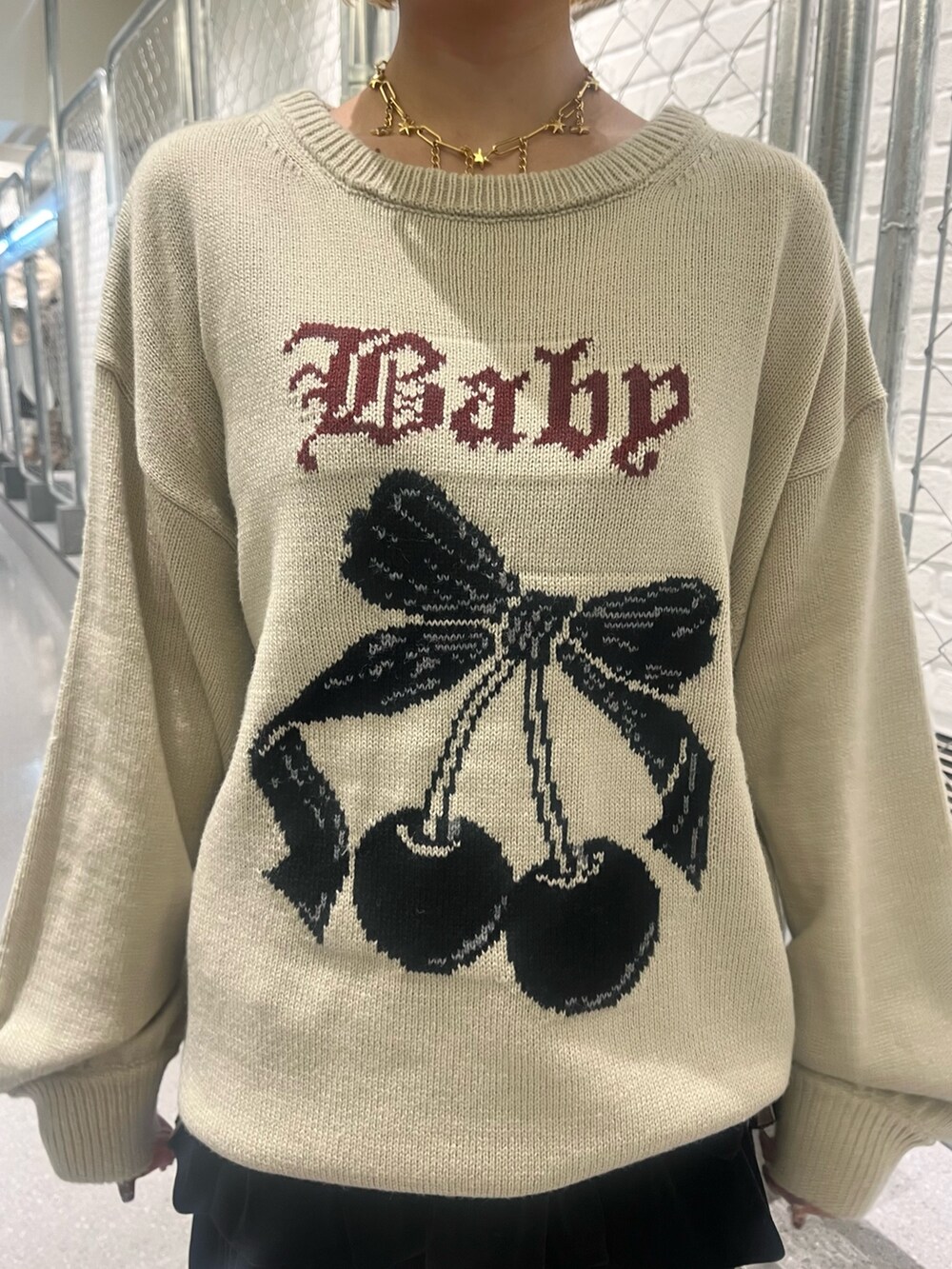 ホワイト系のニット/セーター、ブラック系のスカート、ブラック系のブーツを着用したレディースの秋コーディネートの6枚目の写真