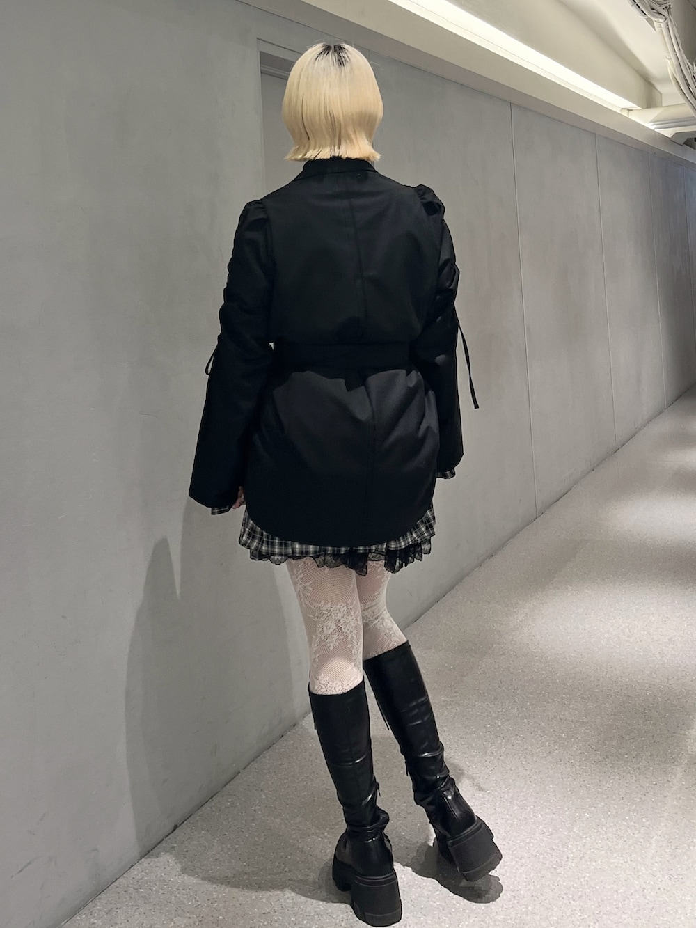 ブラック系のテーラードジャケット、ブラック系のワンピース、ブラック系のブーツを着用したレディースの冬コーディネートの4枚目の写真