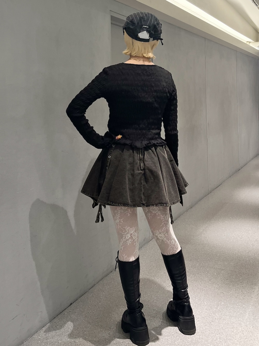 ブラック系のTシャツ/カットソー、ブラック系のデニムスカート、ブラック系のブーツを着用したレディースの冬コーディネートの4枚目の写真