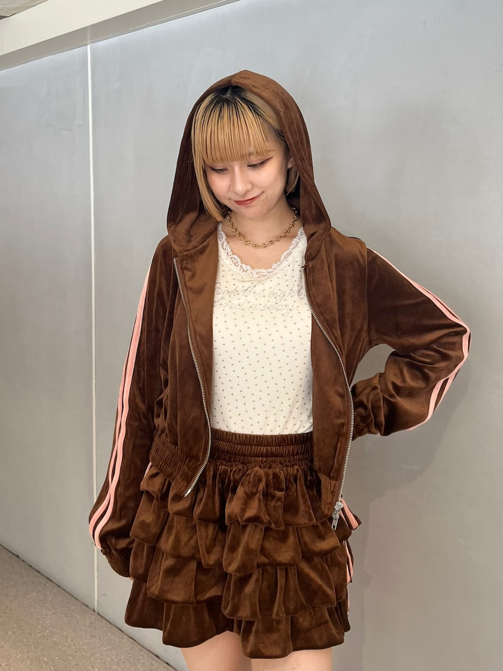 ブラウン系のパーカー、ブラウン系のスカート、ホワイト系のタンクトップを着用したレディースの夏コーディネートの4枚目の写真