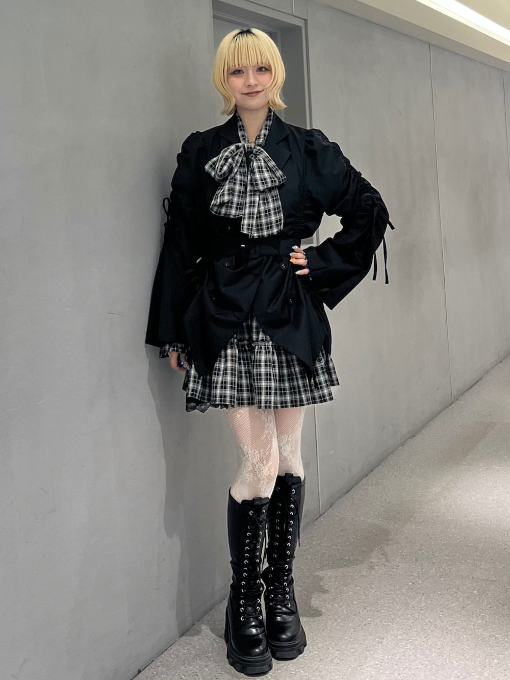 ブラック系のテーラードジャケット、ブラック系のワンピース、ブラック系のブーツを着用したレディースの冬コーディネートの2枚目の写真