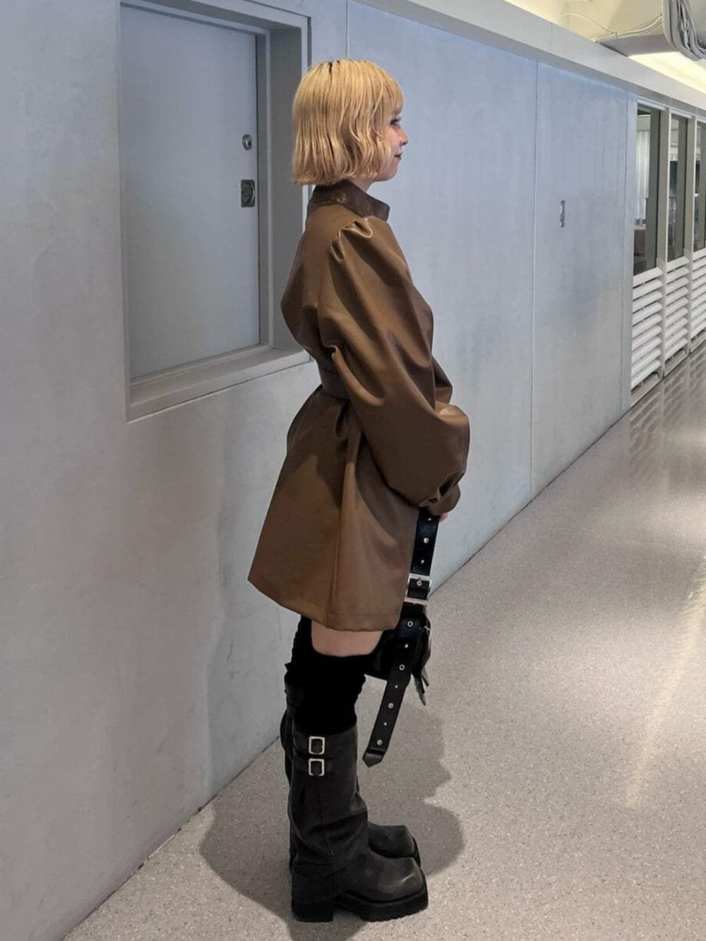 ブラック系のブーツ、ブラウン系のその他アウター、ブラック系のショルダーバッグを着用したレディースの秋コーディネートの2枚目の写真