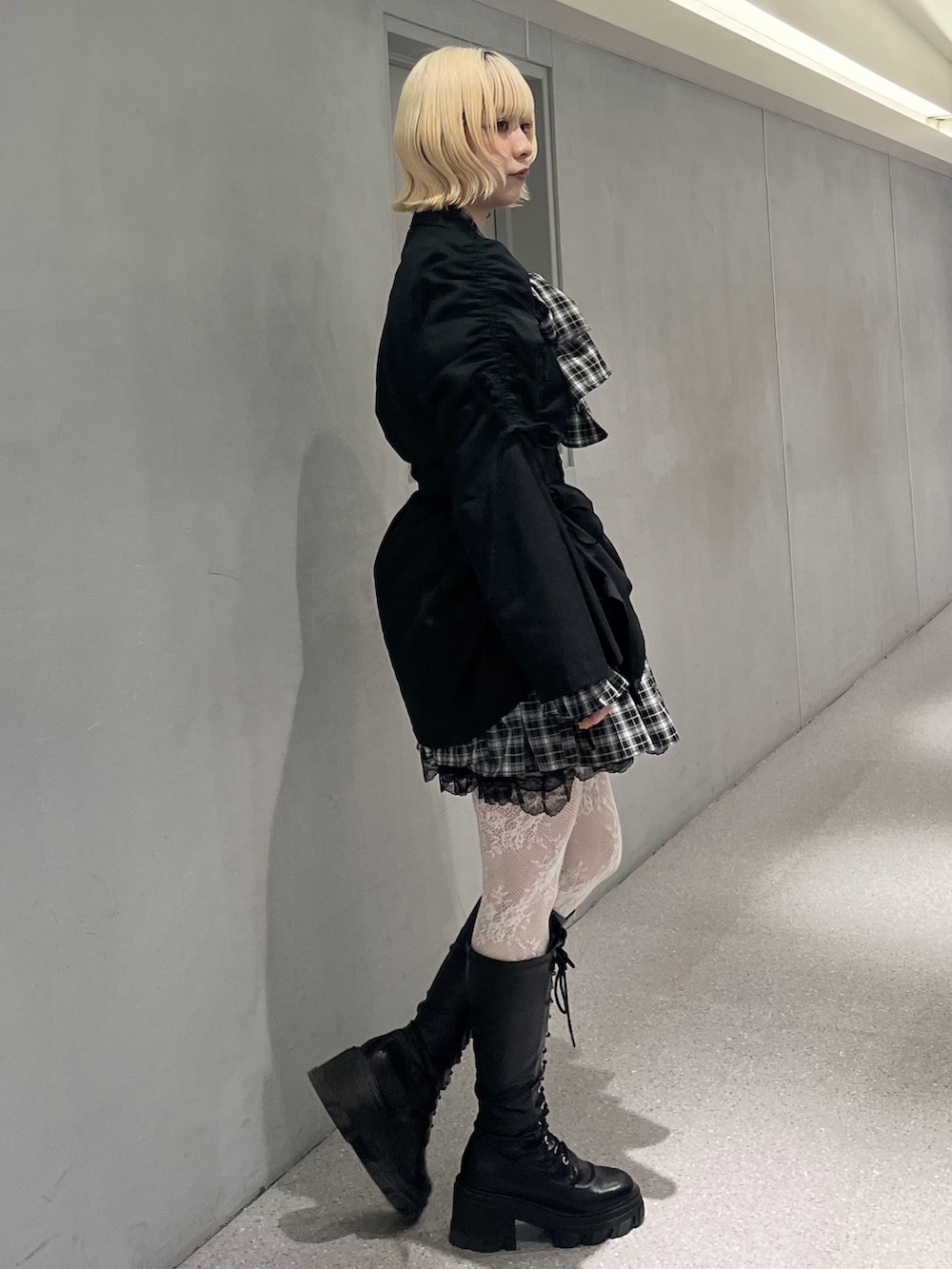 ブラック系のテーラードジャケット、ブラック系のワンピース、ブラック系のブーツを着用したレディースの冬コーディネートの3枚目の写真