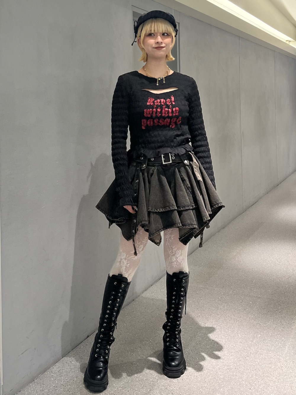 ブラック系のTシャツ/カットソー、ブラック系のデニムスカート、ブラック系のブーツを着用したレディースの冬コーディネートの2枚目の写真