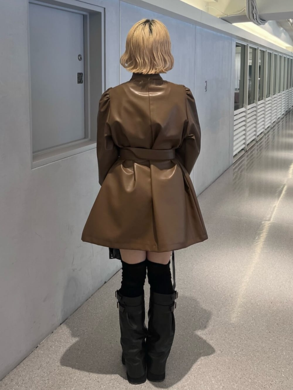 ブラック系のブーツ、ブラウン系のその他アウター、ブラック系のショルダーバッグを着用したレディースの秋コーディネートの3枚目の写真