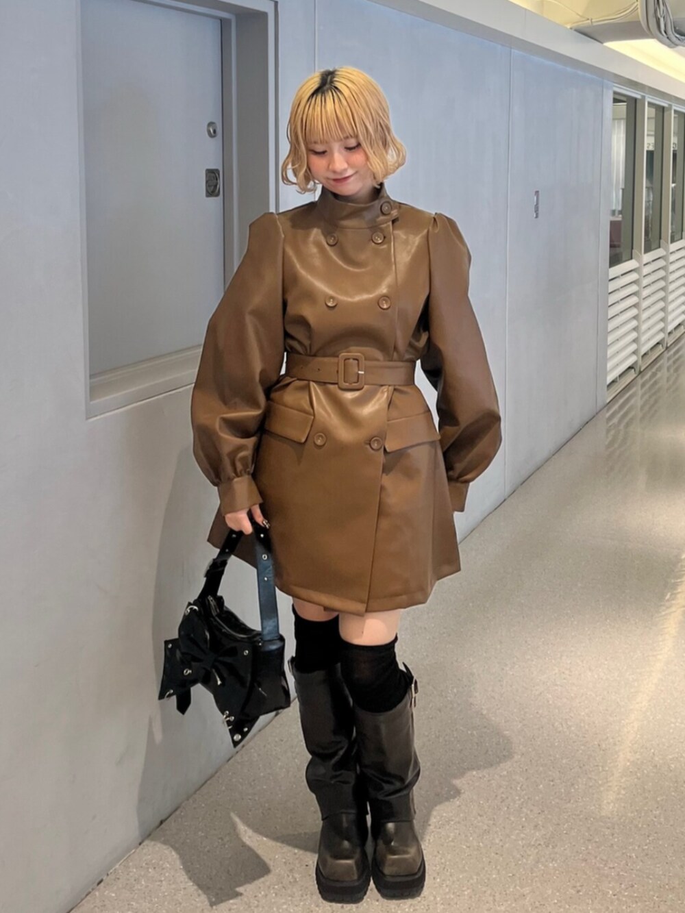 ブラック系のブーツ、ブラウン系のその他アウター、ブラック系のショルダーバッグを着用したレディースの秋コーディネートの4枚目の写真