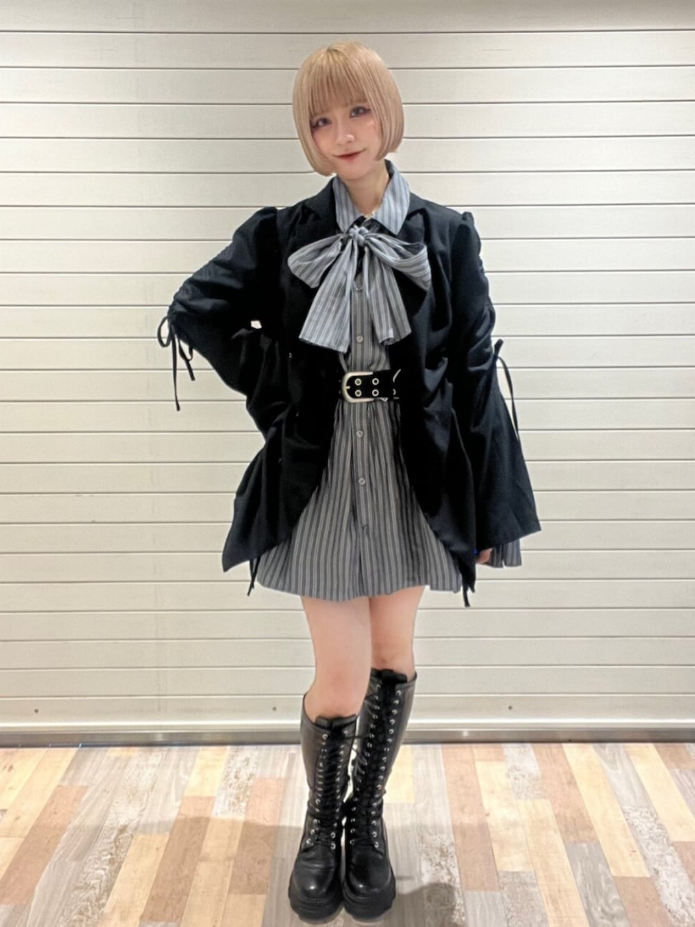 ブラック系のブーツ、ブラック系のテーラードジャケット、グレー系のシャツ/ブラウスを着用したレディースの秋コーディネートの2枚目の写真