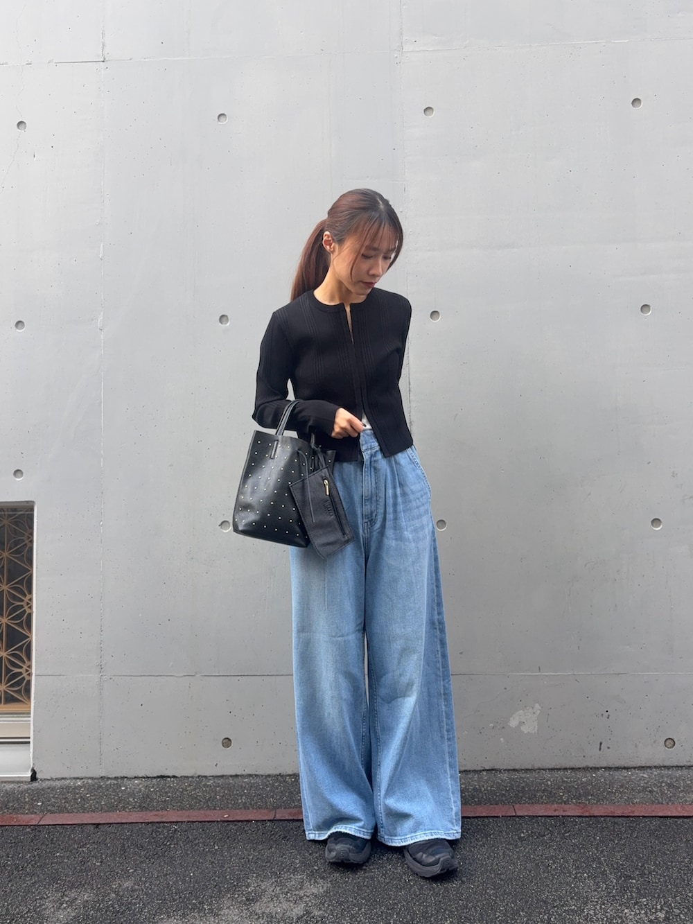 ブラック系のカーディガン/ボレロ、ブルー系のデニムパンツ、ブラック系のトートバッグを着用したレディースの春コーディネートの6枚目の写真