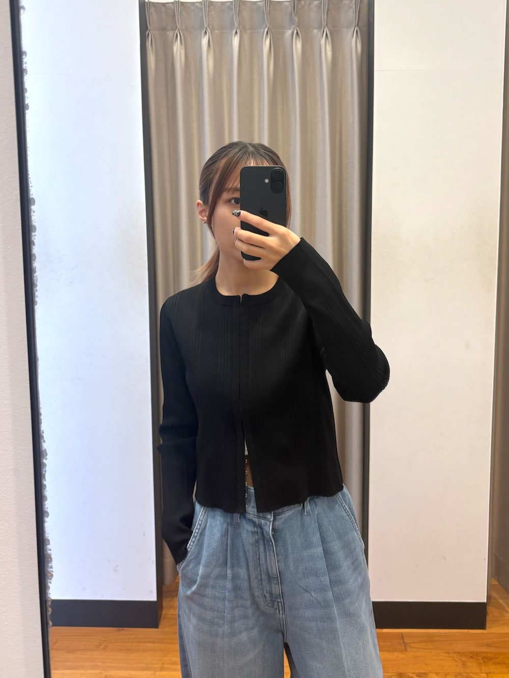 ブラック系のカーディガン/ボレロ、ブルー系のデニムパンツ、ブラック系のトートバッグを着用したレディースの春コーディネートの2枚目の写真