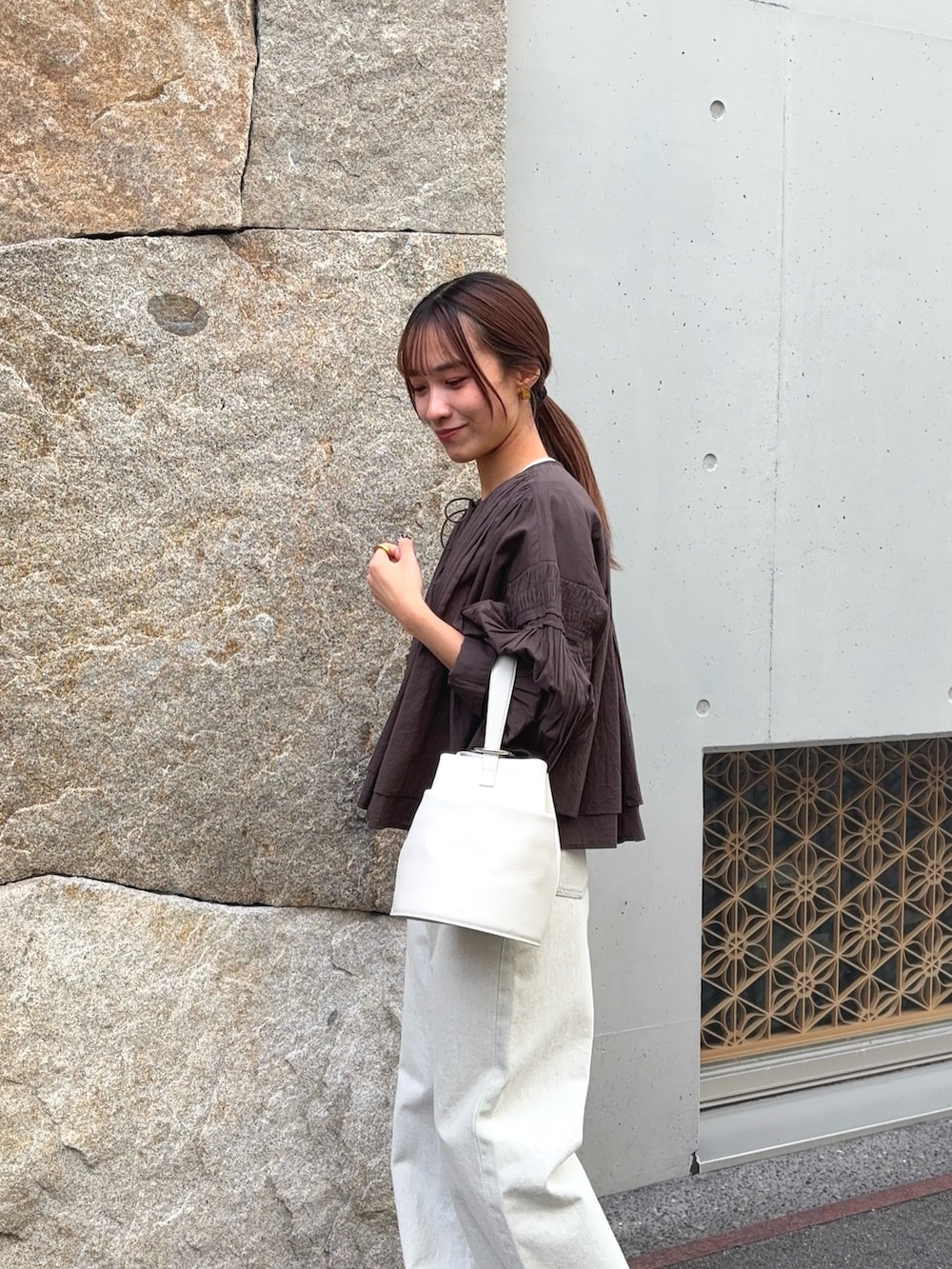 ブラウン系のシャツ/ブラウス、グレー系のデニムパンツ、ブラック系のパンプスを着用したレディースの春コーディネートの4枚目の写真