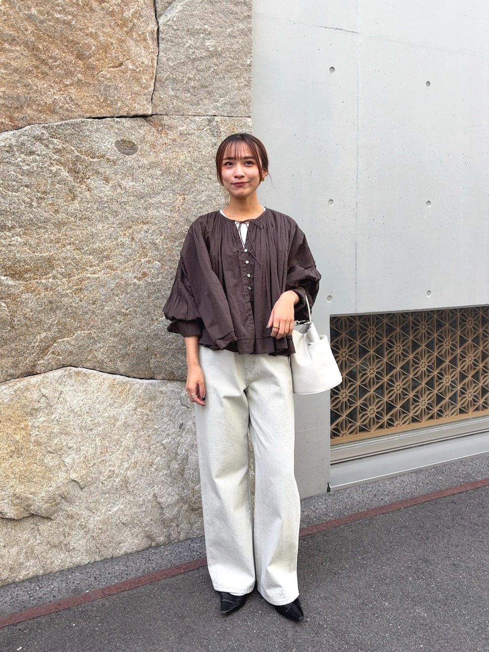 ブラウン系のシャツ/ブラウス、グレー系のデニムパンツ、ブラック系のパンプスを着用したレディースの春コーディネートの2枚目の写真