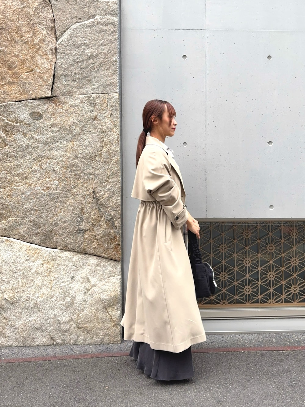 ホワイト系のシャツ/ブラウス、ベージュ系のトレンチコート、グレー系のスカートを着用したレディースの冬コーディネートの3枚目の写真