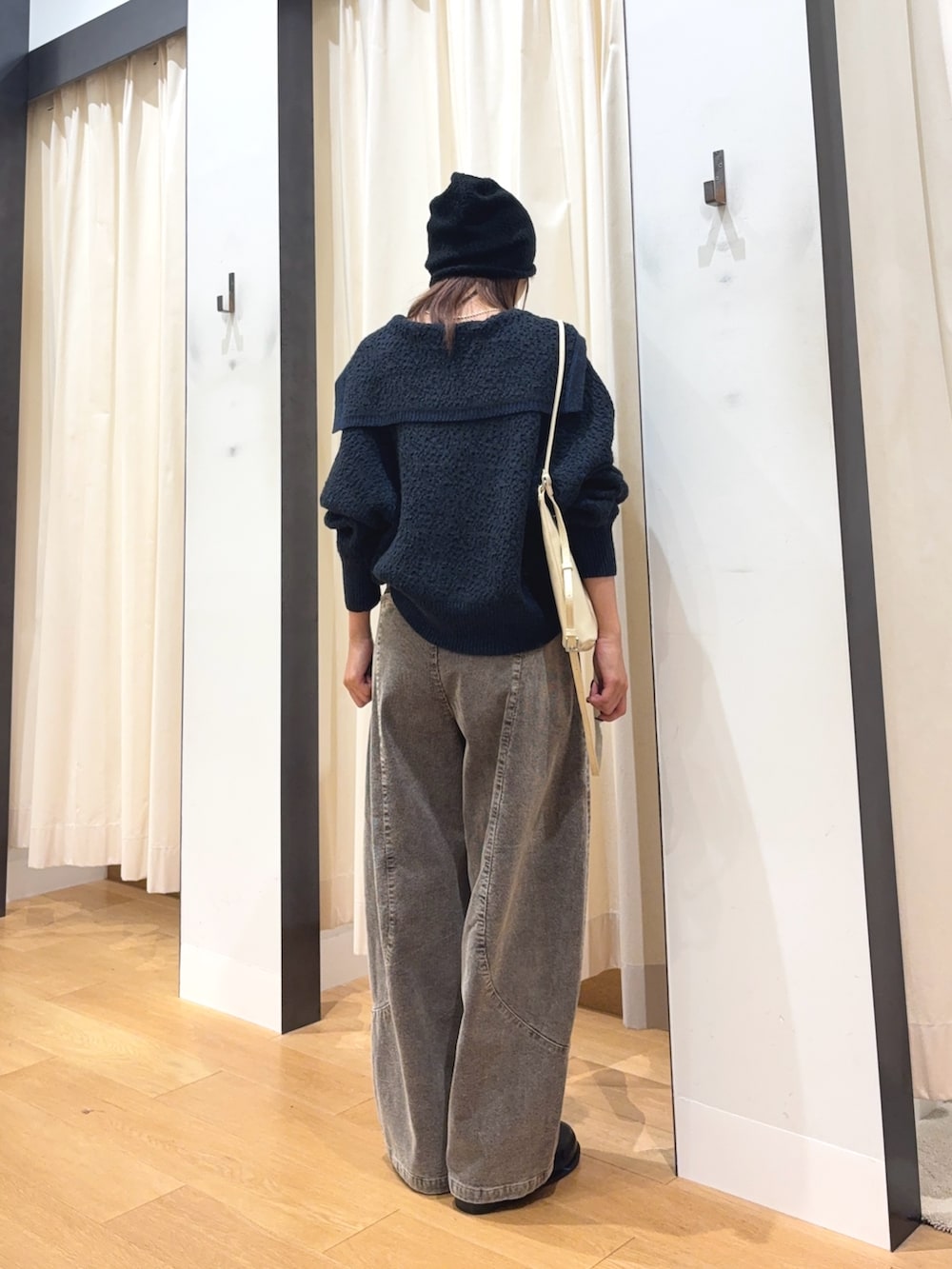 グレー系のニット/セーター、ホワイト系のキャミソール、ホワイト系のショルダーバッグを着用したレディースの秋コーディネートの2枚目の写真
