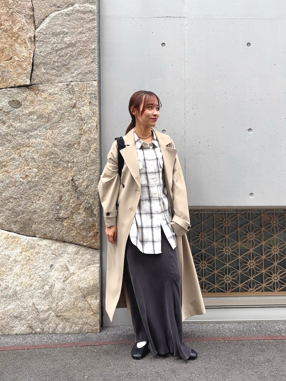 ホワイト系のシャツ/ブラウス、ベージュ系のトレンチコート、グレー系のスカートを着用したレディースの冬コーディネートの2枚目の写真