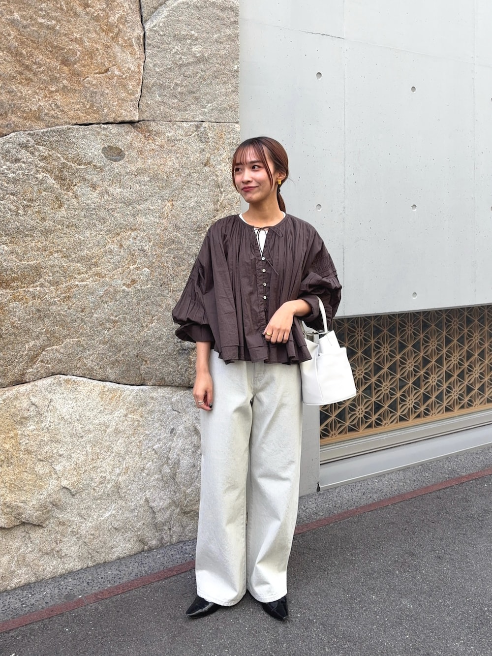 ブラウン系のシャツ/ブラウス、グレー系のデニムパンツ、ブラック系のパンプスを着用したレディースの春コーディネートの3枚目の写真