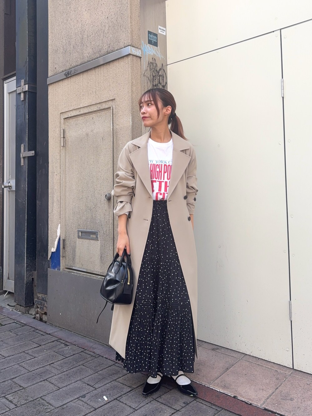 ベージュ系のトレンチコート、ホワイト系のTシャツ/カットソー、ブラック系のパンプスを着用したレディースの春コーディネートの3枚目の写真