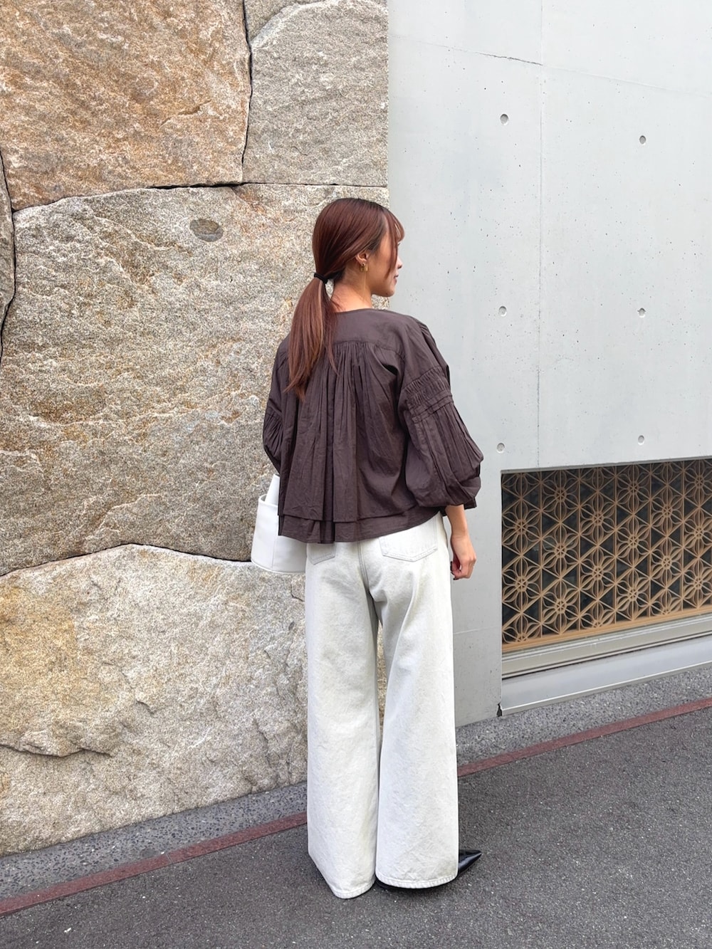 ブラウン系のシャツ/ブラウス、グレー系のデニムパンツ、ブラック系のパンプスを着用したレディースの春コーディネートの5枚目の写真