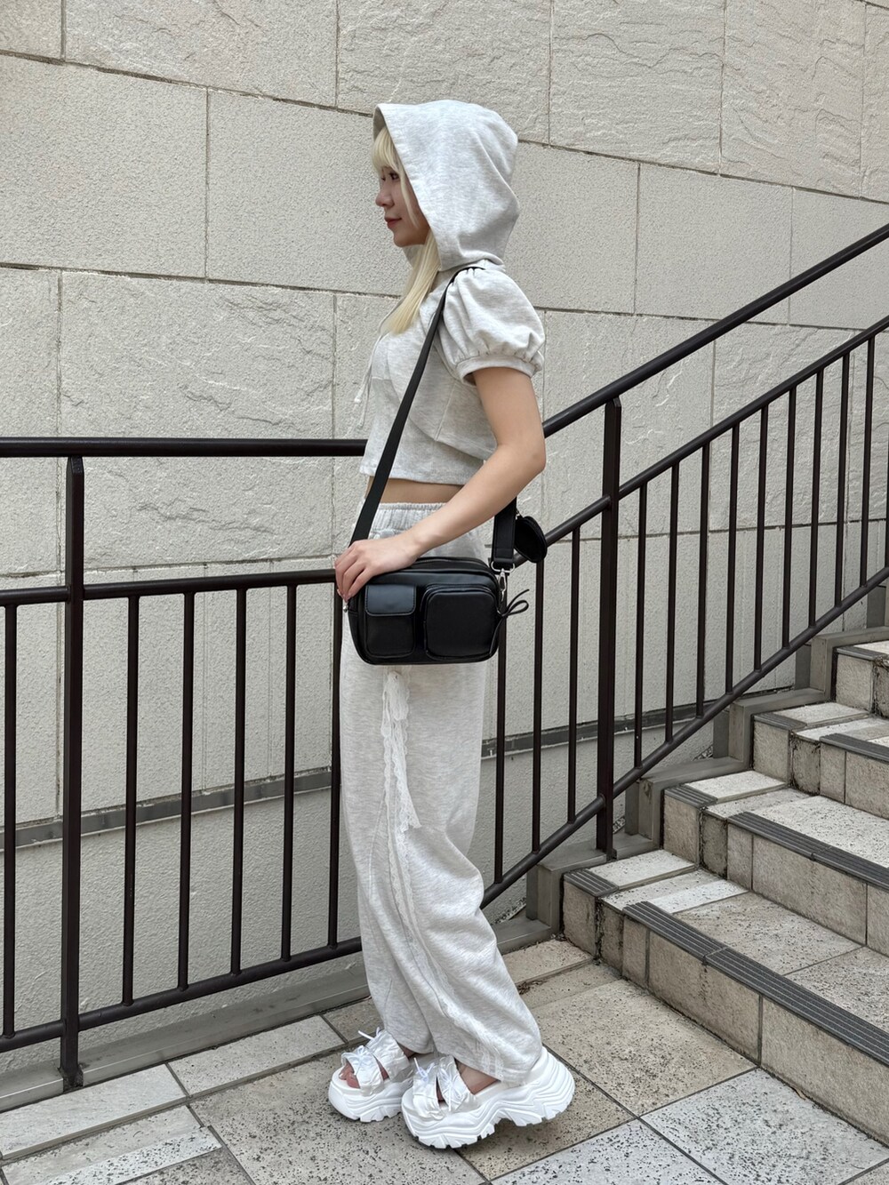 ベージュ系のTシャツ/カットソー、ベージュ系のスウェットパンツ、ブラック系のショルダーバッグを着用したレディースの夏コーディネートの2枚目の写真