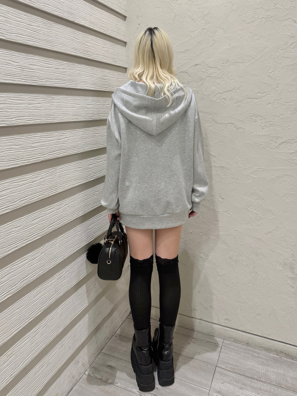 グレー系のパーカー、ブラック系のキャミソール、ブラック系のスカートを着用したレディースの冬コーディネートの3枚目の写真