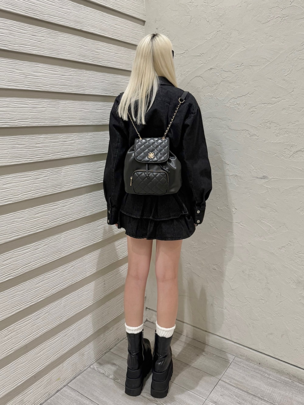 ブラック系のバックパック/リュック、ホワイト系のキャミソール、ブラック系のスカートを着用したレディースの秋コーディネートの2枚目の写真