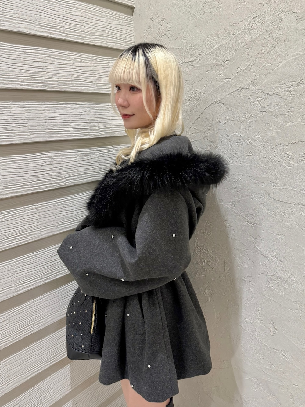 グレー系のその他アウター、ブラック系のニット/セーター、ブラック系のハンドバッグを着用したレディースの冬コーディネートの5枚目の写真