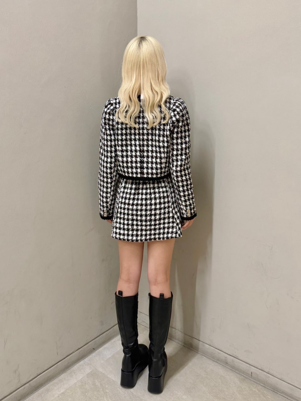 ブラック系のノーカラージャケット、ホワイト系のシャツ/ブラウス、ブラック系のスカートを着用したレディースの秋コーディネートの2枚目の写真