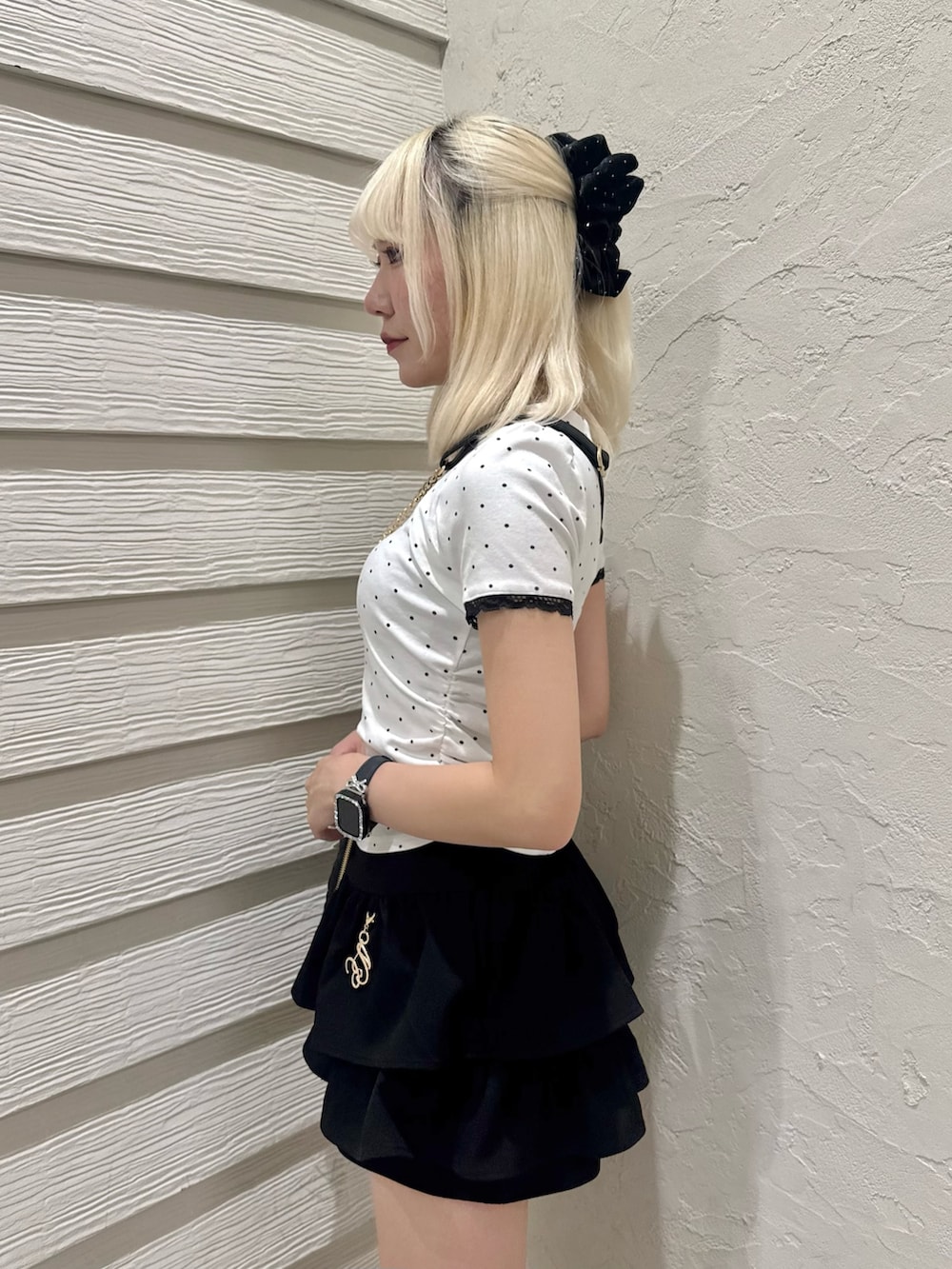 ブラック系のスカート、ブラック系のショルダーバッグ、その他のTシャツ/カットソーを着用したレディースの夏コーディネートの5枚目の写真