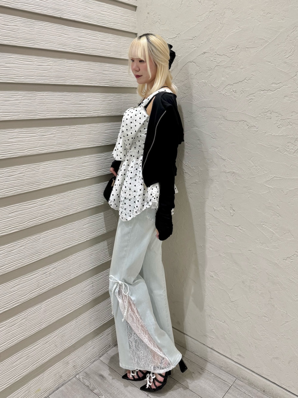 ブラック系のショルダーバッグ、ブルー系のデニムパンツ、ブラック系のサンダルを着用したレディースの夏コーディネートの2枚目の写真