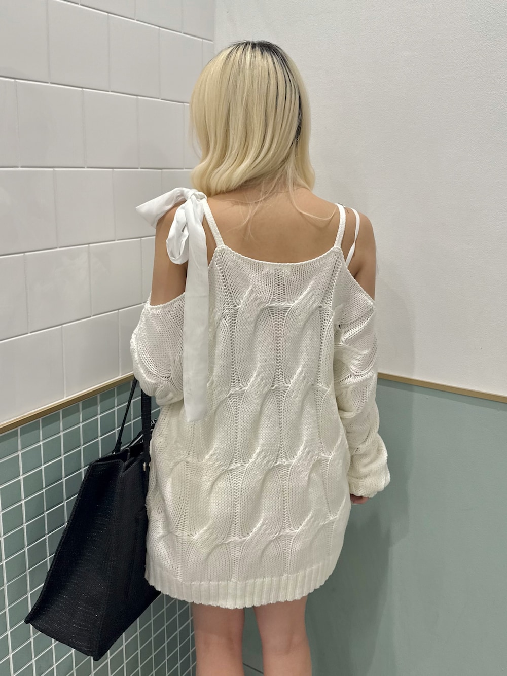 ブラック系のトートバッグ、ブラック系のブーツ、ホワイト系のワンピースを着用したレディースの冬コーディネートの7枚目の写真