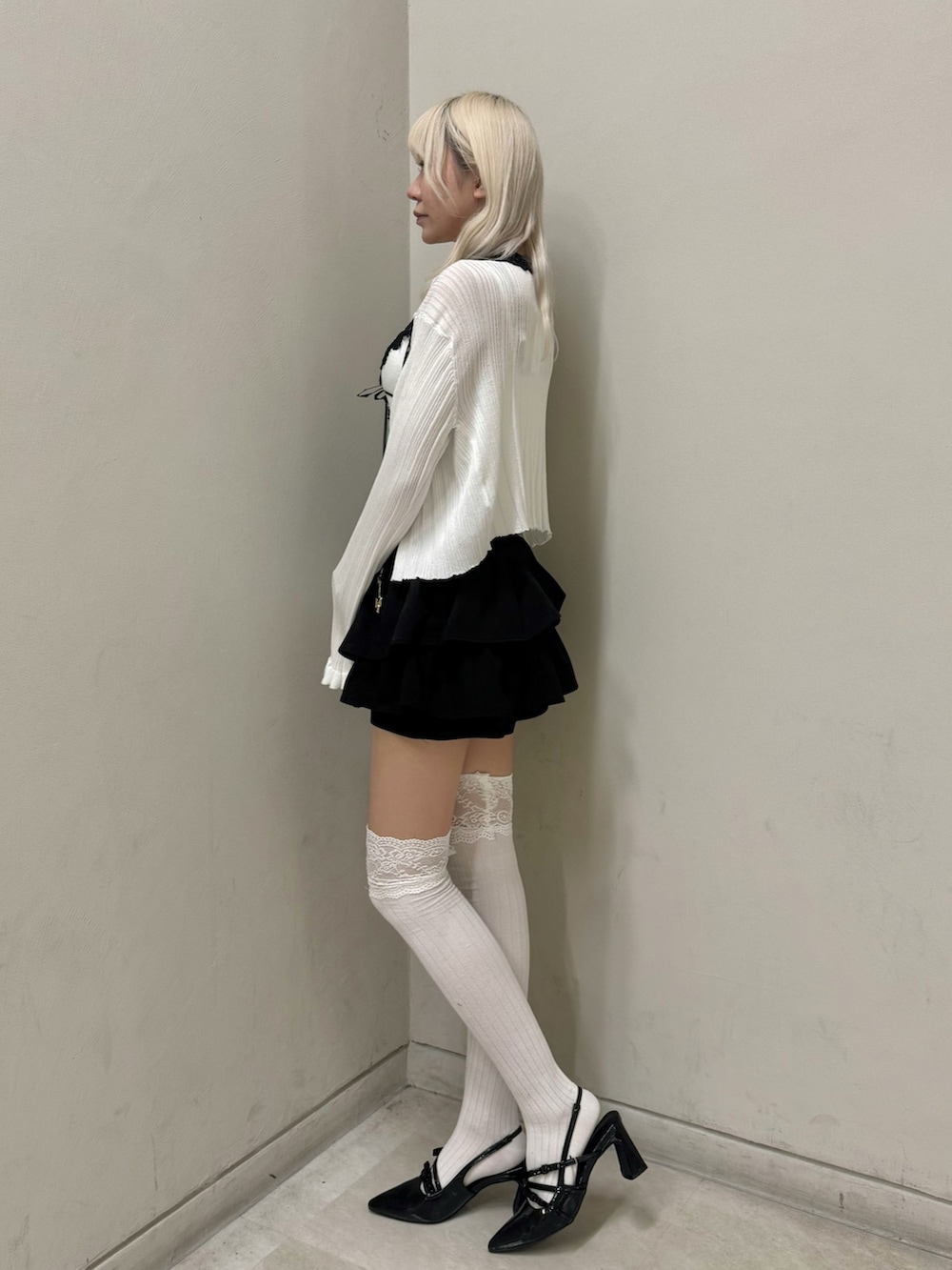 ブラック系のパンプス、ホワイト系のキャミソール、ブラック系のスカートを着用したレディースの春コーディネートの2枚目の写真
