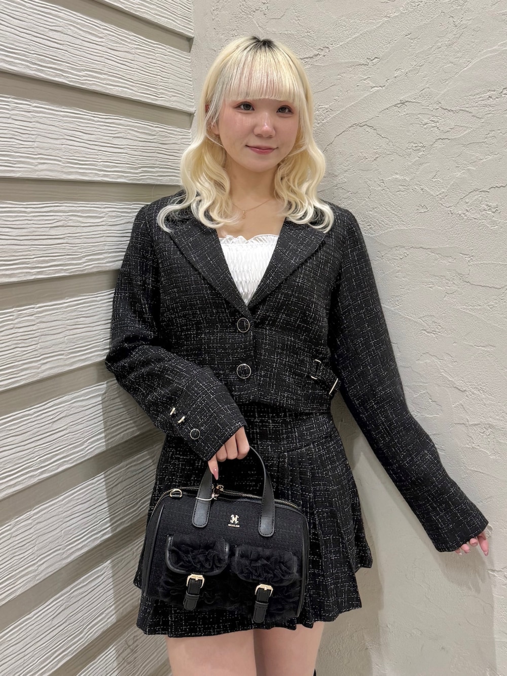 ブラック系のショルダーバッグ、ブラック系のスカート、ブラック系のテーラードジャケットを着用したレディースの冬コーディネートの4枚目の写真