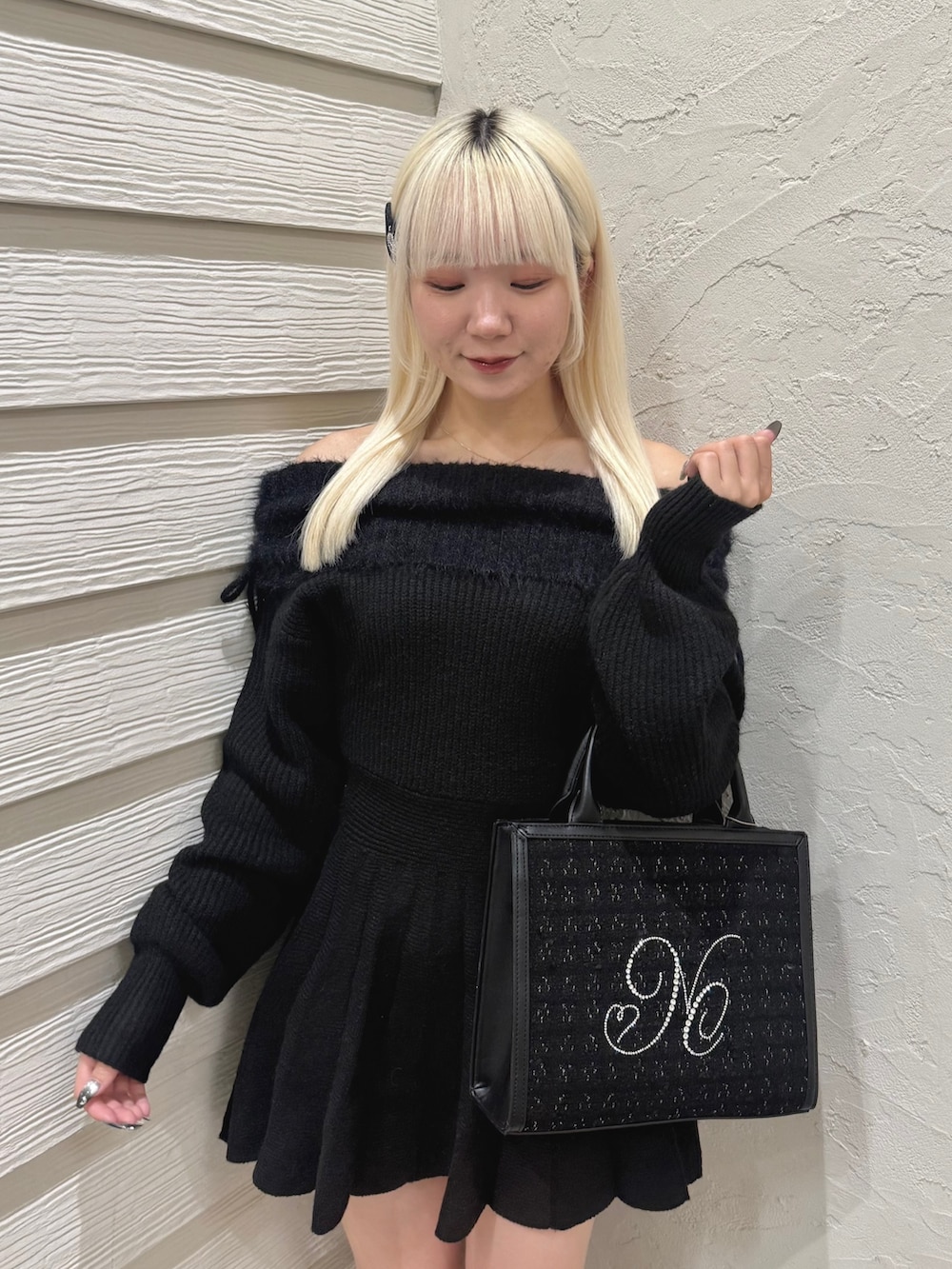 ブラック系のワンピース、ブラック系のトートバッグ、ブラック系のブーツを着用したレディースの秋コーディネートの4枚目の写真