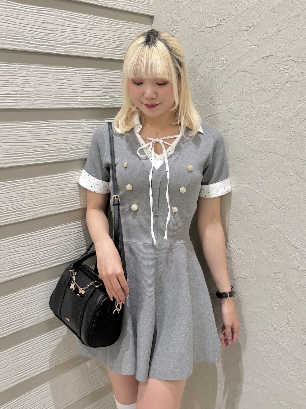 ブラック系のパンプス、ブラック系のショルダーバッグ、グレー系のワンピースを着用したレディースの夏コーディネートの4枚目の写真