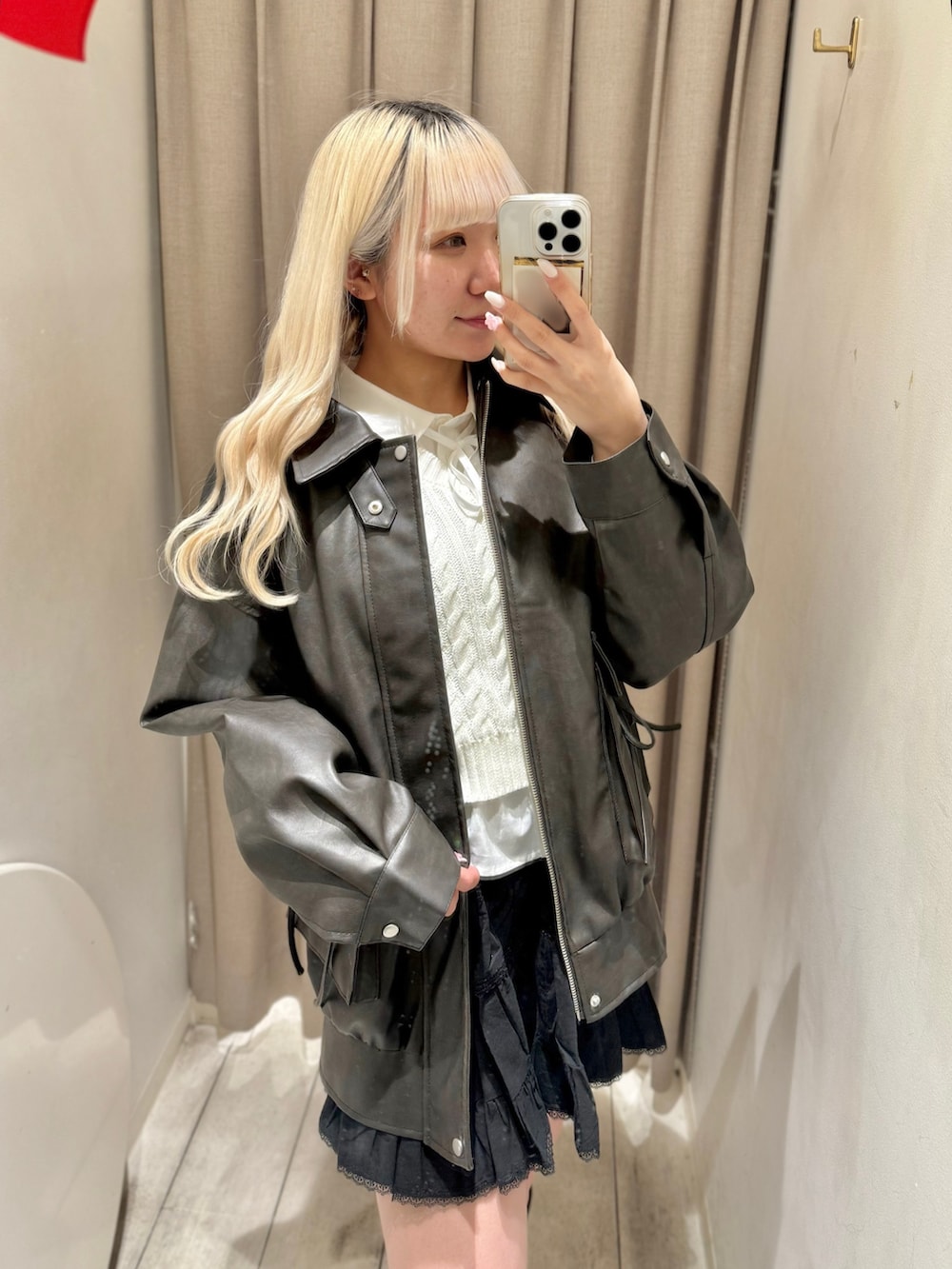 ホワイト系のシャツ/ブラウス、ブラック系のスカート、ブラック系のブルゾンを着用したレディースの冬コーディネートの2枚目の写真