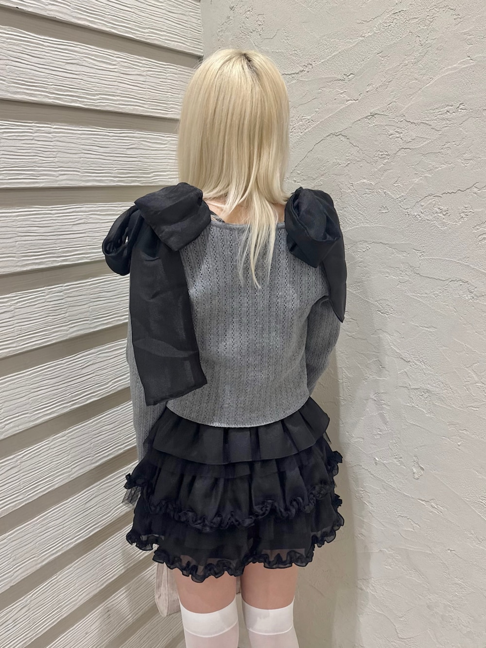 グレー系のカーディガン/ボレロ、ブラック系のスカート、ブラック系のパンプスを着用したレディースの春コーディネートの6枚目の写真